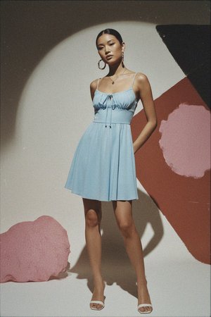 Elegancka niebieska mini sukienka z wiązaniem z przodu i zwiewną spódnicą