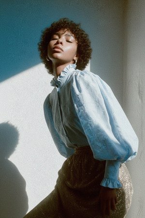 Bluzka w kolorze niebieskim z fakturą, falbaniastym kołnierzem i bufiastymi rękawami