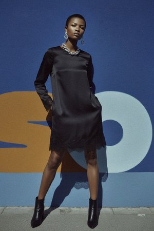 Elegancka czarna mini sukienka z koronkową lamówką i długimi rękawami