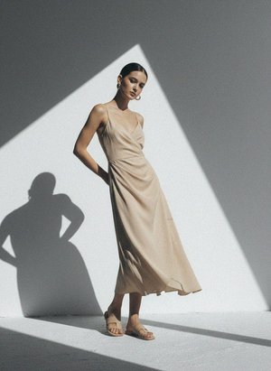 Elegancka beżowa sukienka midi bez rękawów