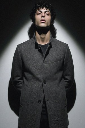 Płaszcz w kolorze szarym z teksturą i stójką zapinaną z przodu na guziki